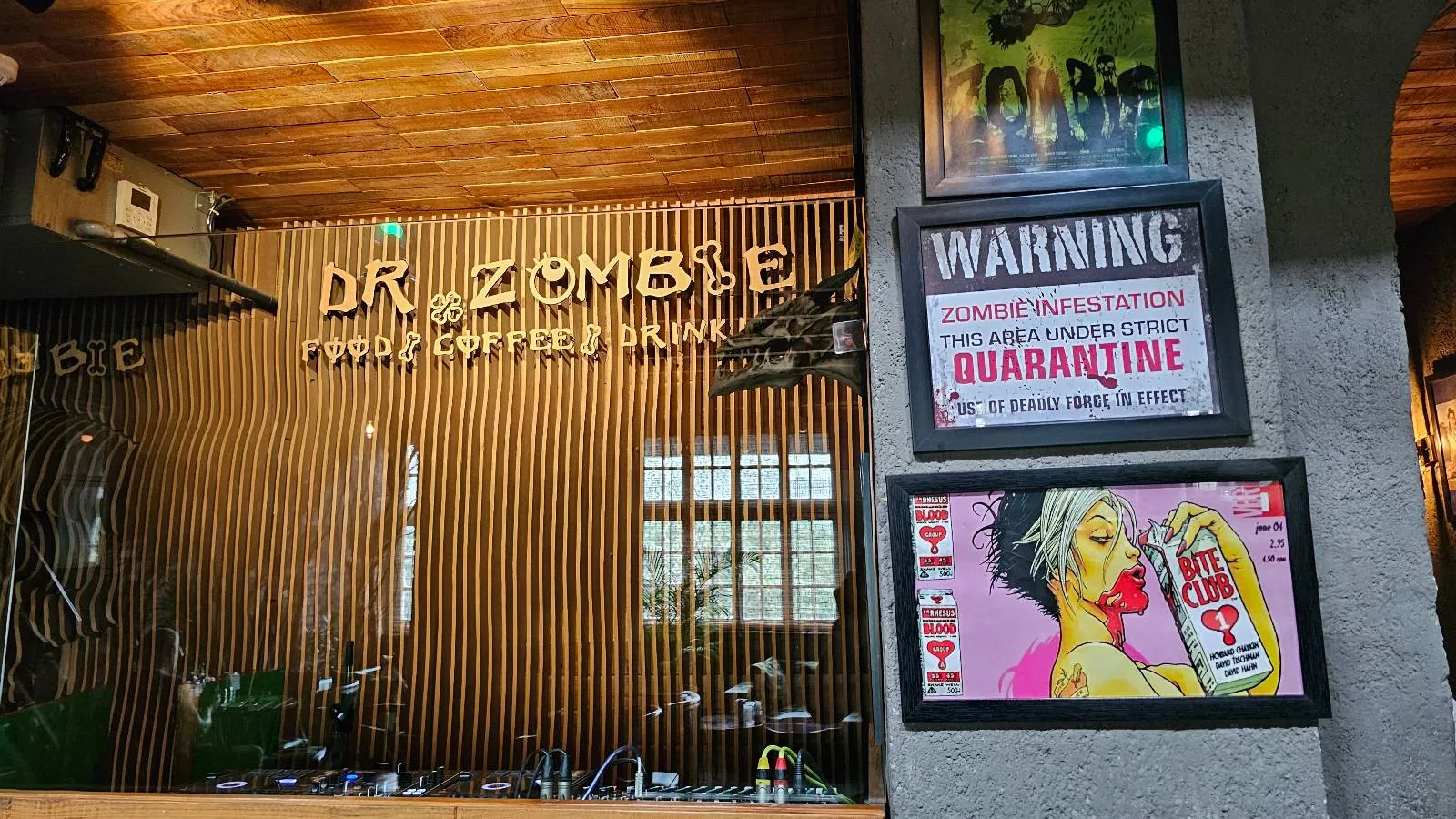 A room with a sign that reads "Dr. Zombie Horror Hospital Bar" in neon lights. Posters on the wall include a "Warning: Zombie Contamination Quarantine" notice and a graphic image of a person holding a weapon with a red mask.