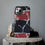 Thumbnail: A smartphone with a black, red, and white marble-patterned case stands upright on a stack of rough stones.