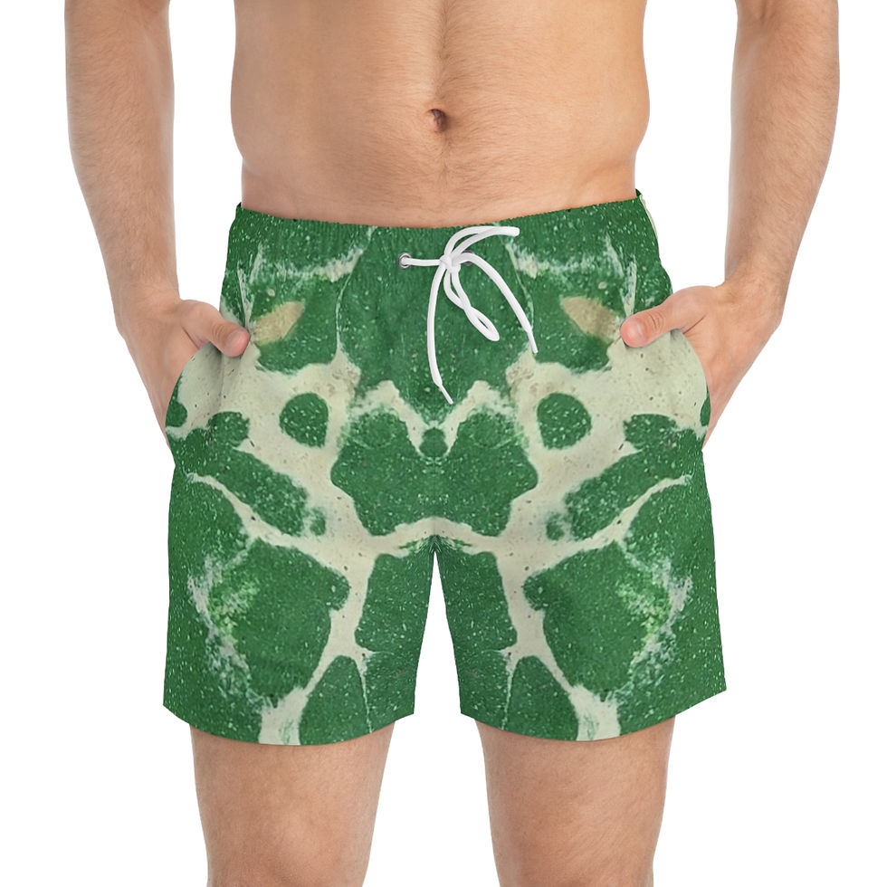 Man wearing green and white cracked marble effect swim trunks with hands in pockets.