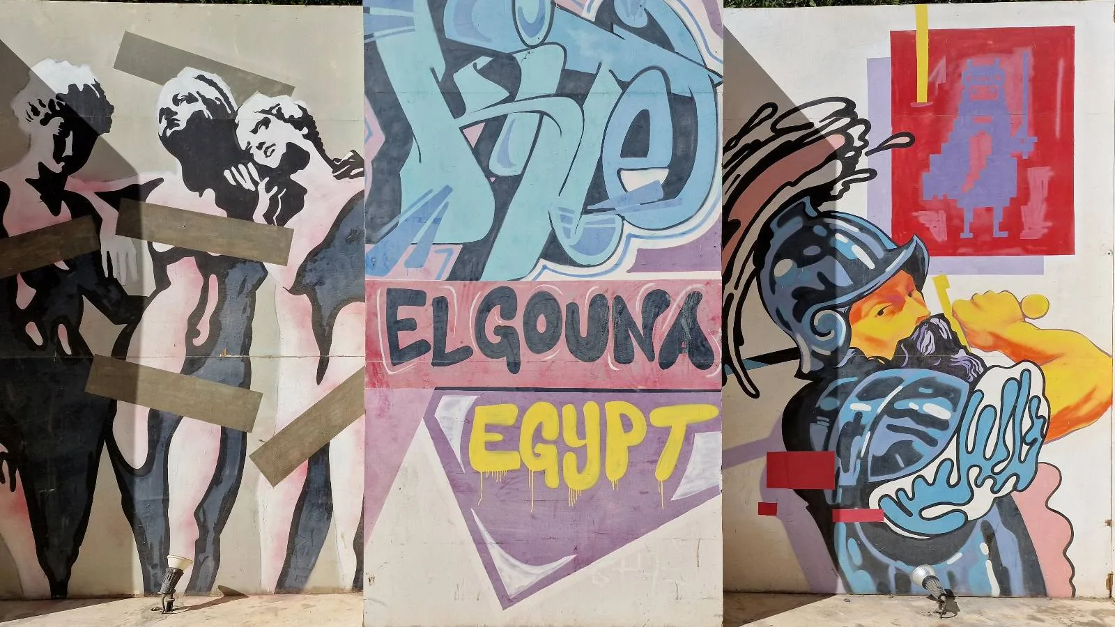 Colorful graffiti mural featuring abstract figures, text reading "ELGOUNA EGYPT," and a stylized warrior with a helmet and shield.