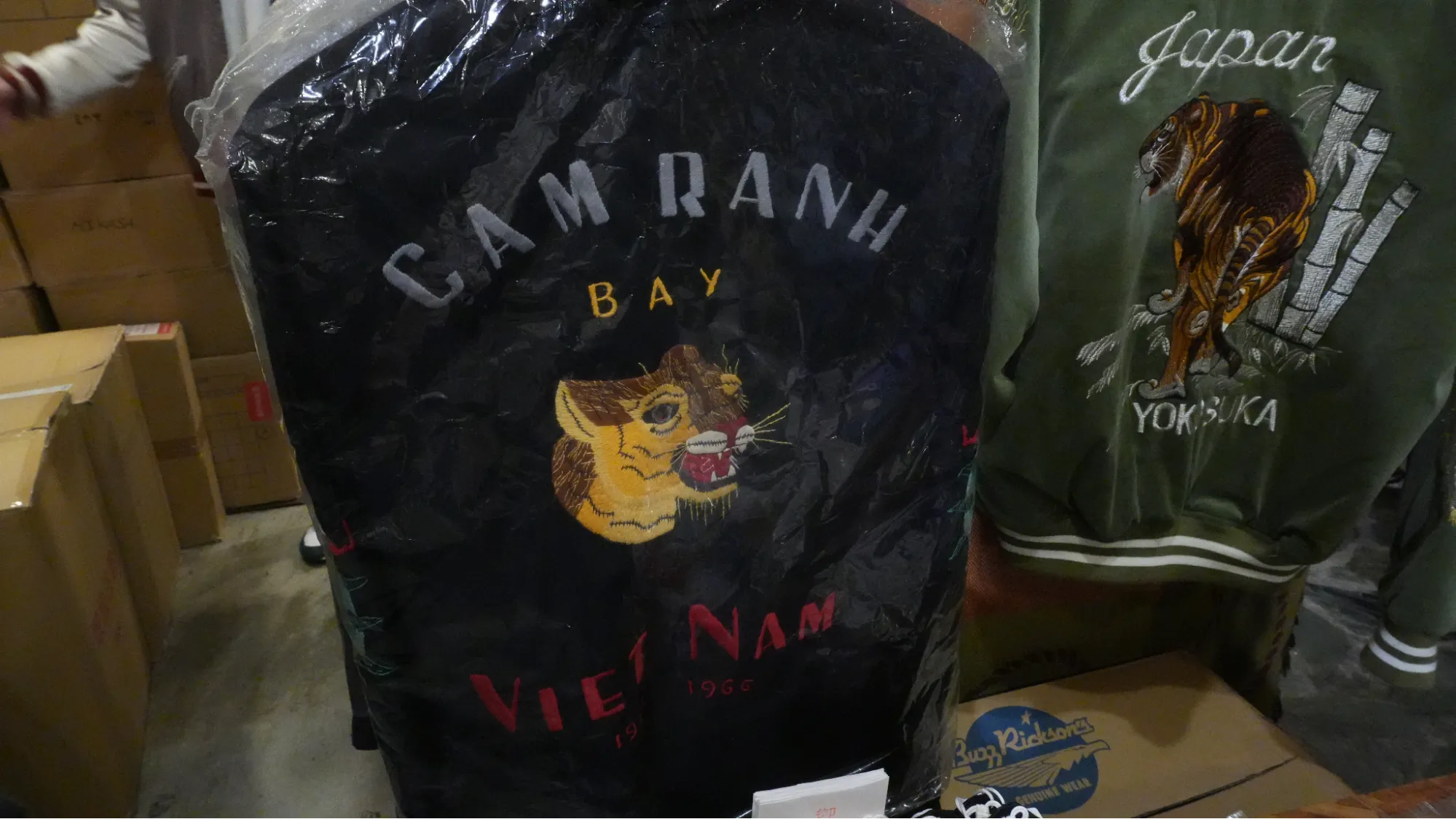 一件黑色的外套，背面印有英文字以及一隻老虎刺繡