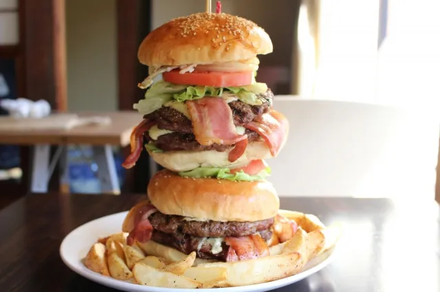 疊著十分多層的漢堡與薯條放在盤子上