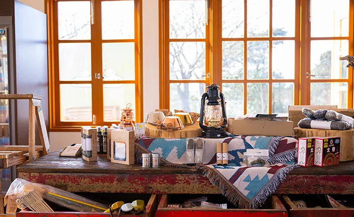 長桌上擺放著露營照燈、民俗風桌巾與各項物品