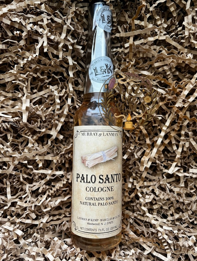 Three 7.5 oz Palo Santo cologne bottles lying in a brown wicker basket with kraft crinkle paper
