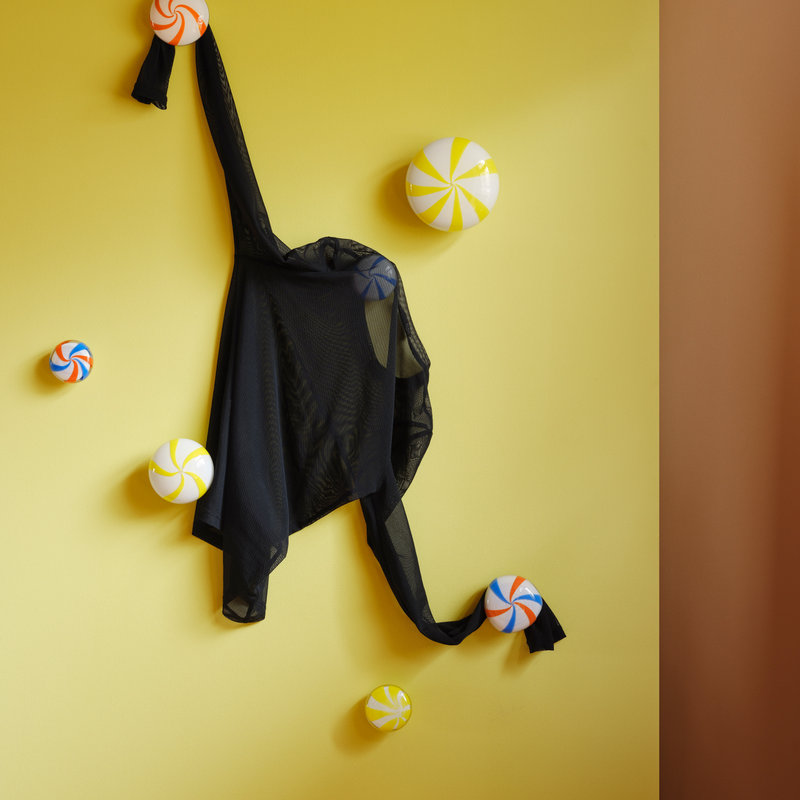 coatCANDY glass coat hooks by STUDIO BERG on a wall