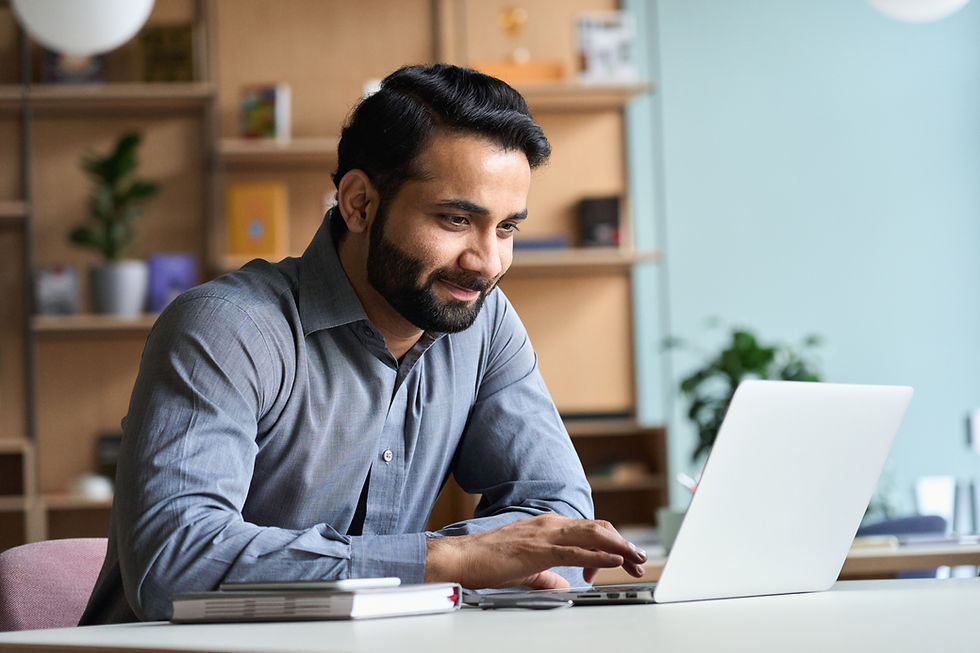 A man sitting at his laptop, talking with his doctor about his mental health progress.