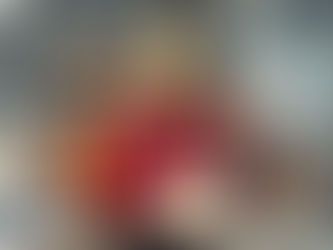 A man holding a cake with candles, surrounded by team mates.