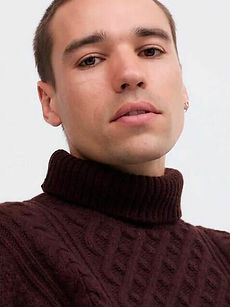 Kit - headshot of male model with short dark hair, wearing a pale T-shirt, and holding a blade of grass in front of his face, represented by ROC Talent Agency UK