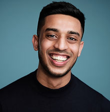 Abdul - headshot of male model with short dark hair, light stubble and wearing a black top, represented by ROC Talent Agency UK