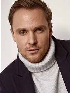 Gerry -  headshot of male model with light stubble, and wearing a white turtleneck, represented by ROC Talent Agency UK
