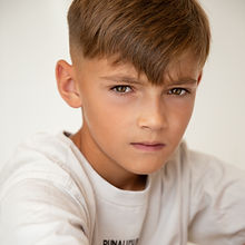 Bradley - a headshot of a junior model with short hair, an intense expression, and wearing a white t-shirt, represented by ROC Talent Agency UK