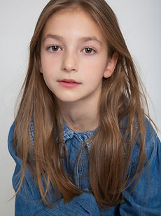 Dottie - a headshot of a junior model with long straight hair, a natural expression, and wearing a white vest top, represented by ROC Talent Agency UK
