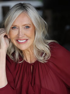 Zoe N - A headshot of a classic model with long wavy hair, a natural expression and wearing a grey blazer represented by Roc Talent agency UK