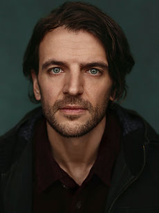 Wayne E - headshot of a male actor with dark brown hair and a natural smile, represented by ROC Talent Agency UK