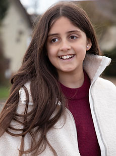 Sophia A - a headshot of a junior model with long straight hair, a wide smile, and wearing a yellow patterned top, represented by ROC Talent Agency UK 