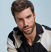 Chez - headshot of male model with dark hair, a strong jawline, and a beige zip-up, represented by ROC Talent Agency UK