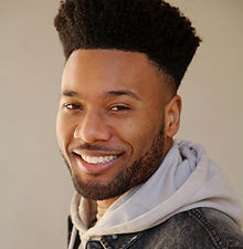 Andrew P - headshot of male model with a high top fade haircut, groomed beard, a wide smile and wearing a light hoodie, represented by ROC Talent Agency UK
