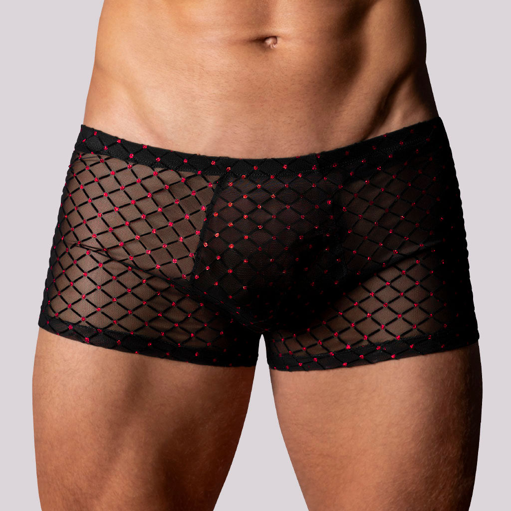 Front view male model wearing captivating classic mini short trunks in black sheer stretch mesh with ruby red dots.