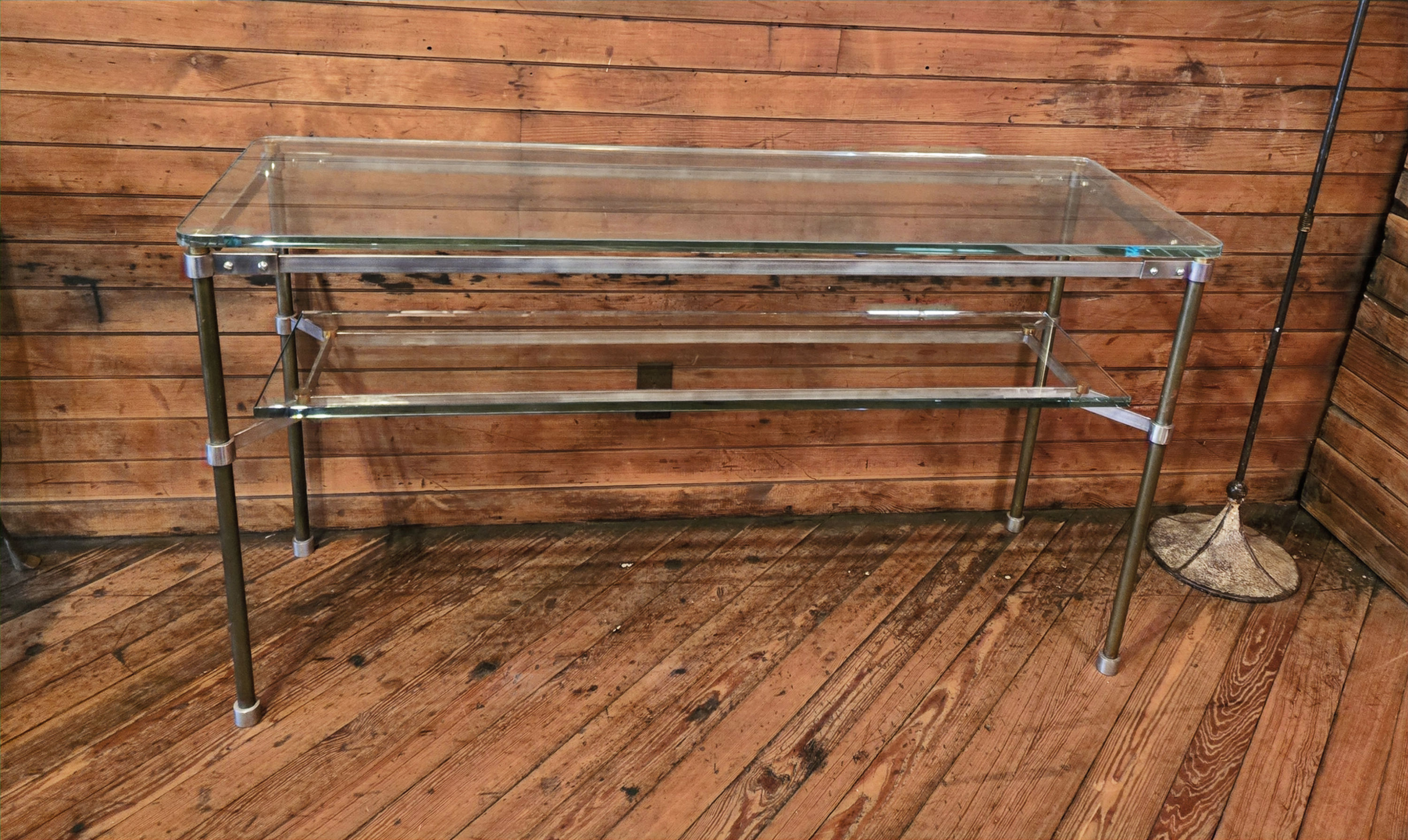 Joseph Stannard Design Glass and steel console table against weathered wooden wall