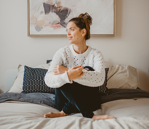 Marie-Christine assise sur son lit, les jambes croisées, l'air serein.