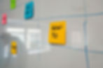 Colourful sticky notes on a whiteboard mapping how a services firm defines what it measures.