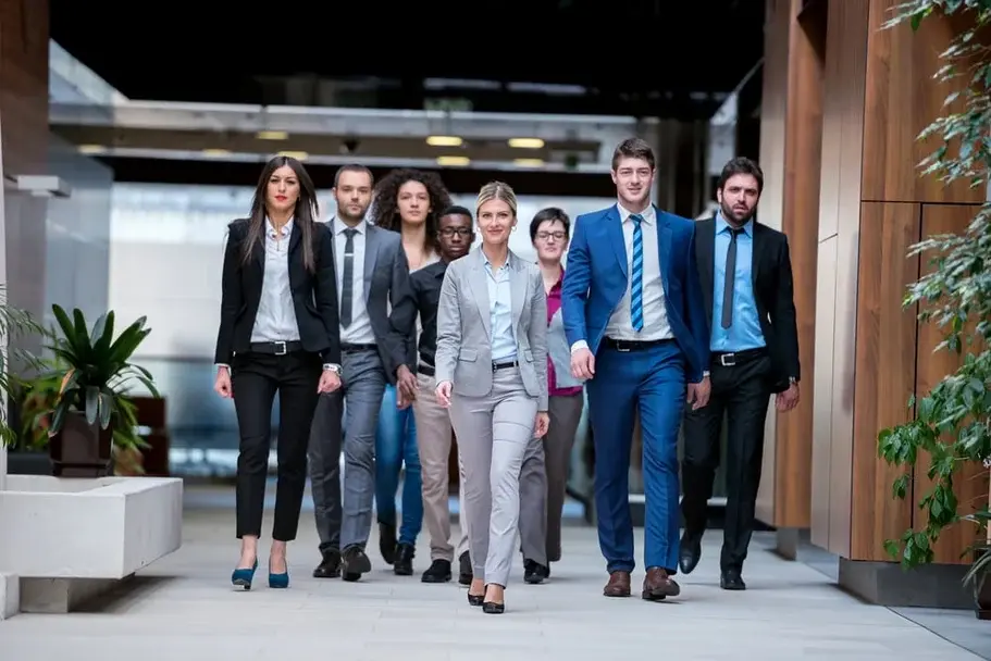 Oameni mergând prin birou în activitatea zilnică, simbol al transformării integrate