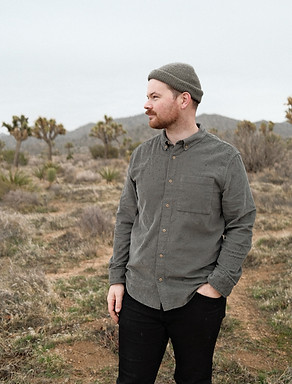 Profile image of Gavin Brown standing in Joshua tree looking camera left in a green shirt and green hat.