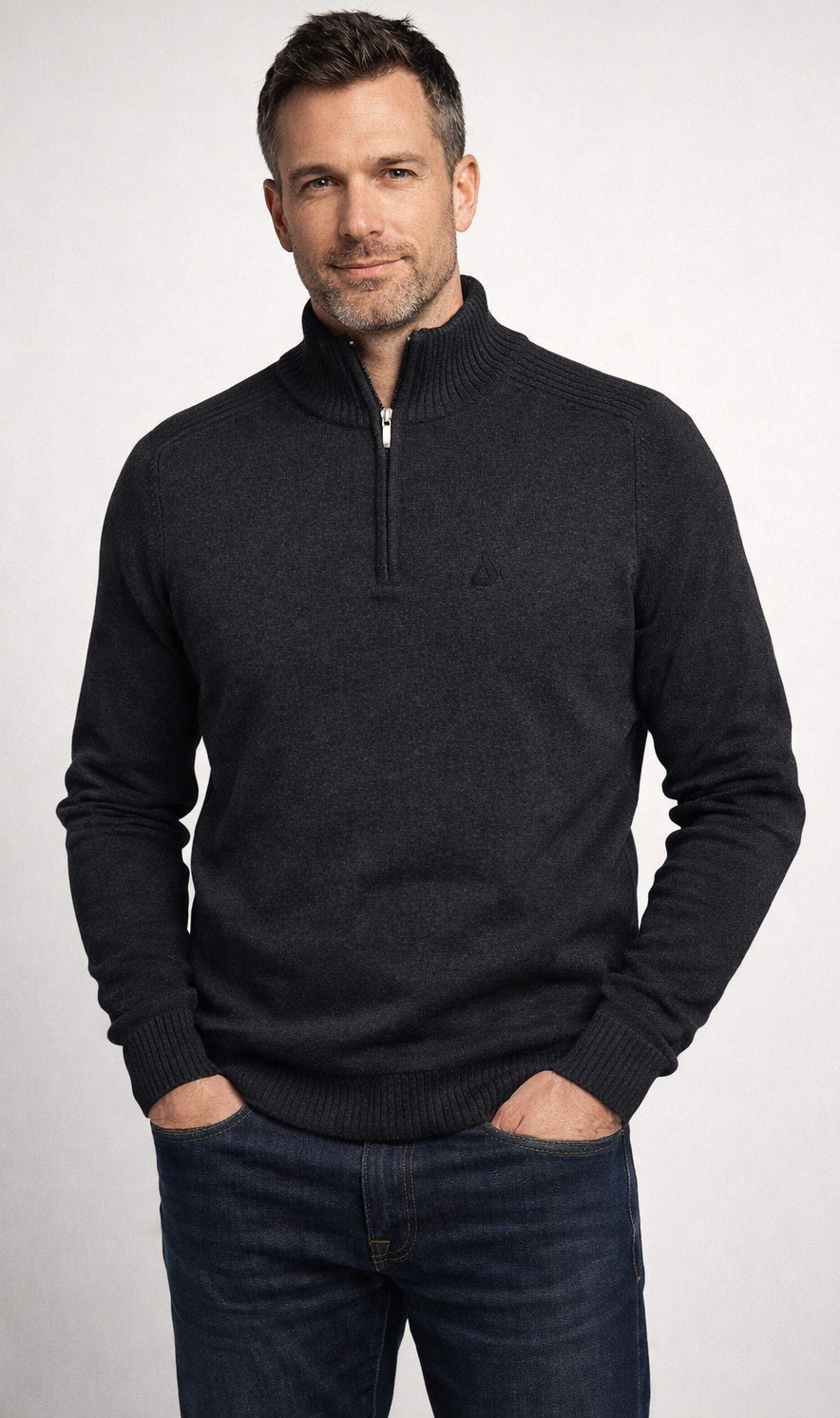 Thumbnail: Male Model wearing a dark grey zip up sweater with a black embroider