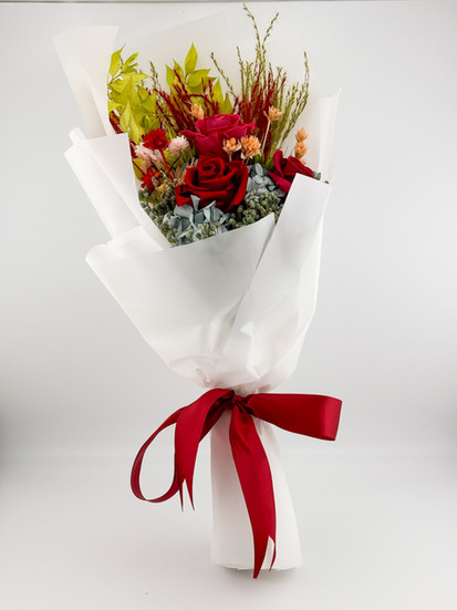 SKfleur 3 Cardinal Rose Preserved Flower Bouquet featuring three vibrant cardinal red preserved roses accented with mixed yellow filler flowers and a red ribbon tie.