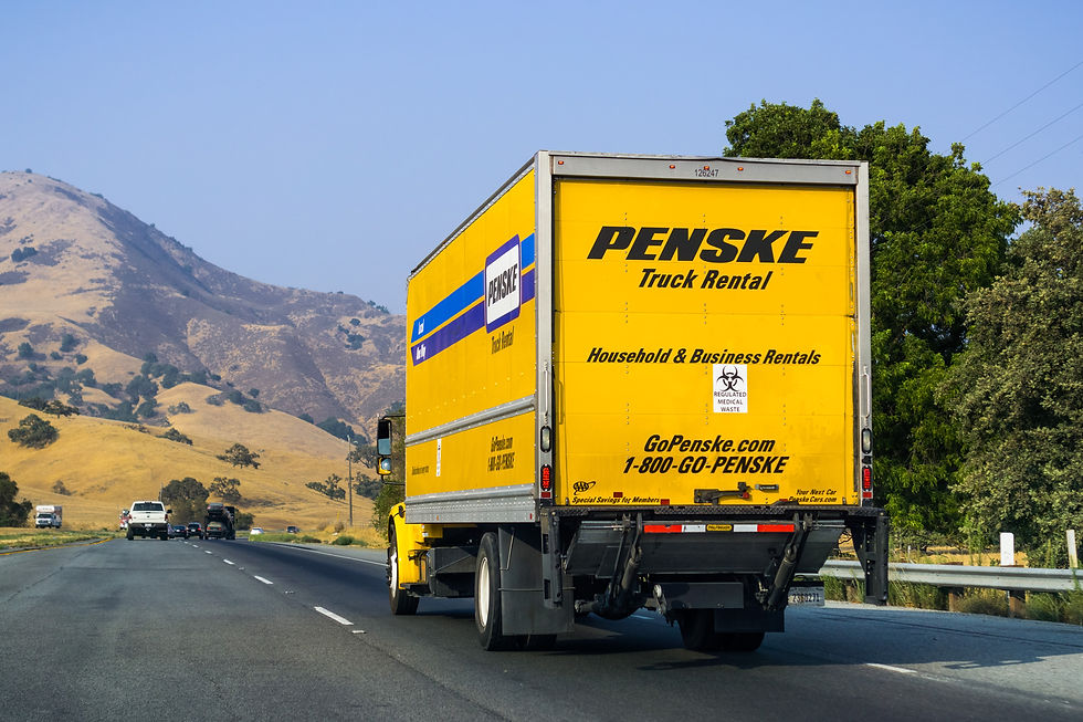 Penske box truck driving down a highway road in the mountains