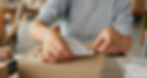 person placing a packing label on a box