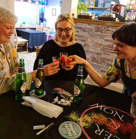 People clinking their drinnks glasses together at a Queer and Now event