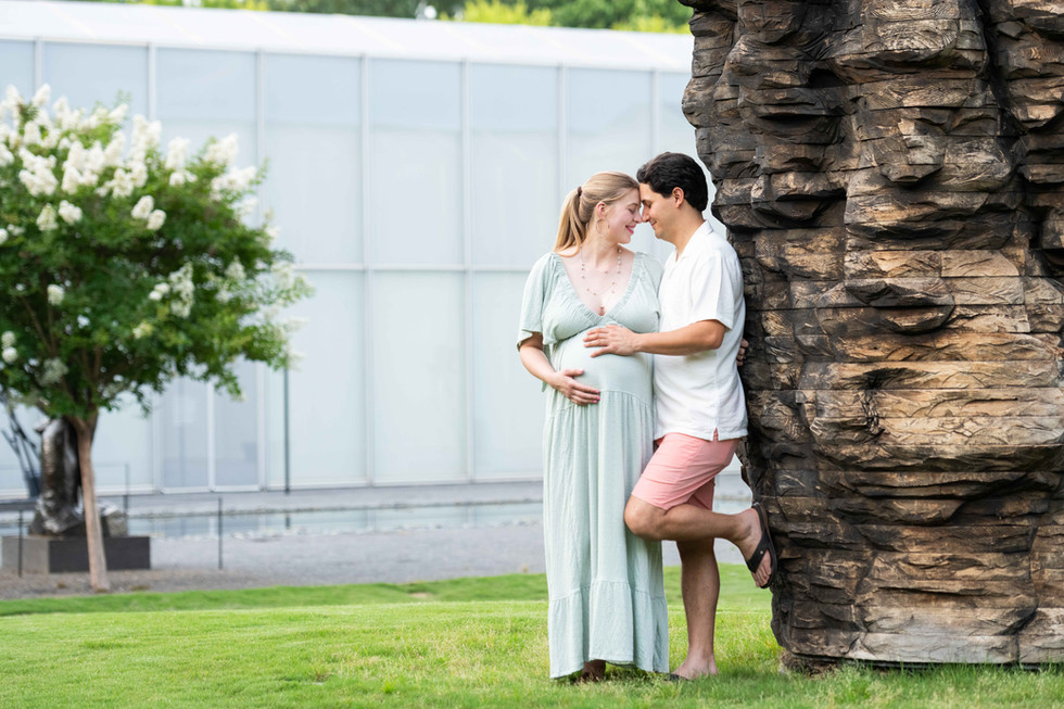 Dreamy flower field maternity photos Charlotte NC.  Couple standing in yellow flower field at North Carolina Museum of Art.