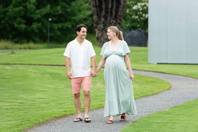 Dreamy flower field maternity photos Charlotte NC.  Couple standing in yellow flower field at North Carolina Museum of Art.