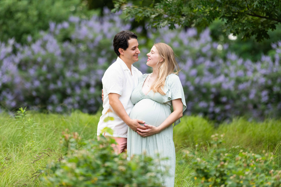 Dreamy flower field maternity photos Charlotte NC.  Couple standing in yellow flower field at North Carolina Museum of Art.