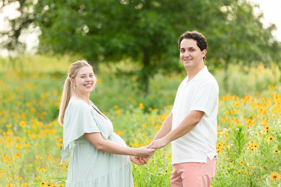 Dreamy flower field maternity photos Charlotte NC.  Couple standing in yellow flower field at North Carolina Museum of Art.