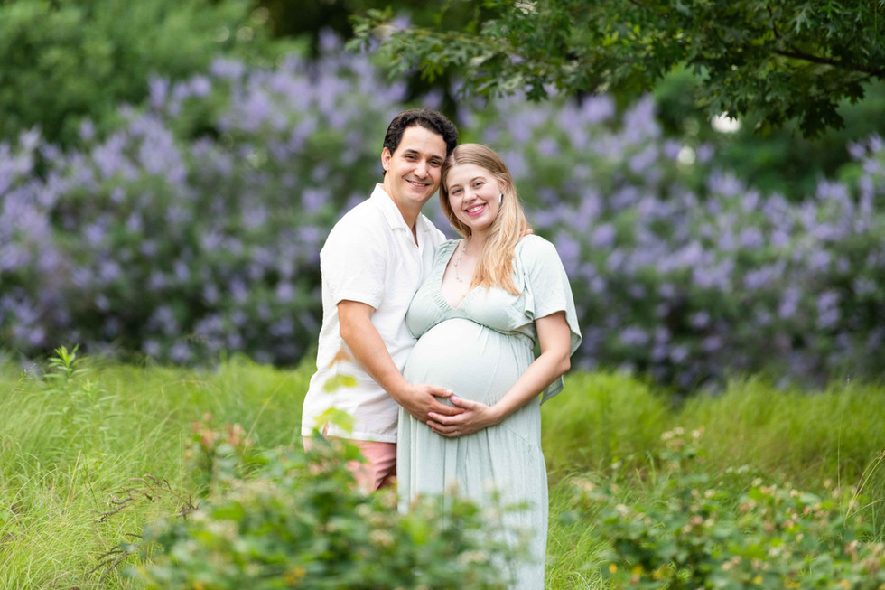 Dreamy flower field maternity photos Charlotte NC.  Couple standing in yellow flower field at North Carolina Museum of Art.