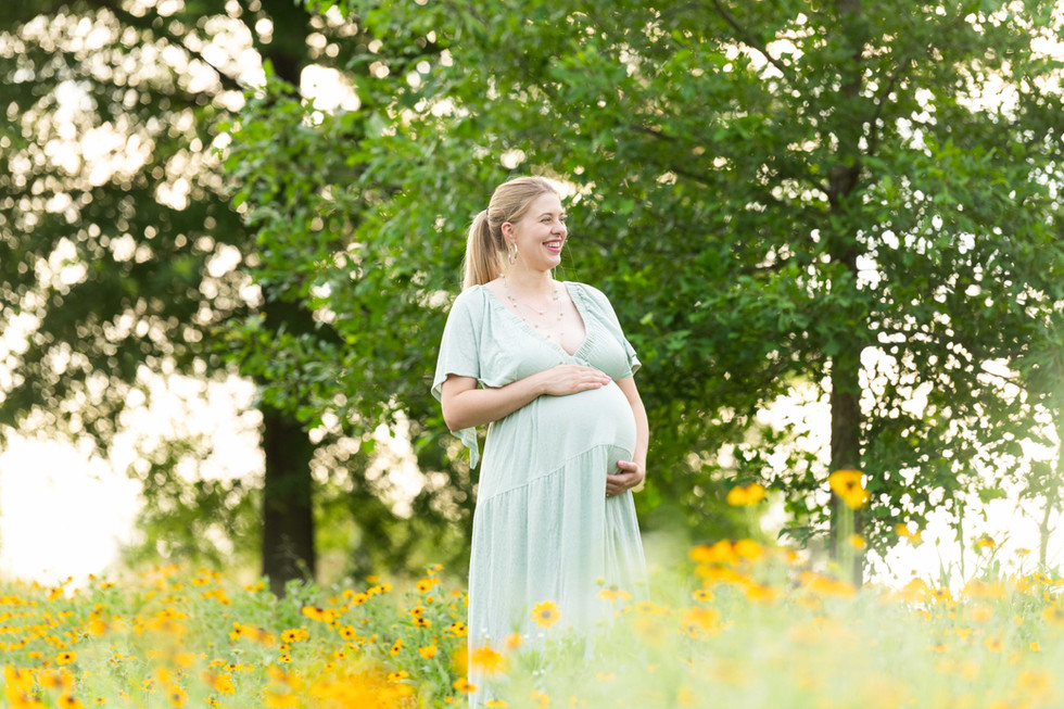 Dreamy flower field maternity photos Charlotte NC.  Couple standing in yellow flower field at North Carolina Museum of Art.