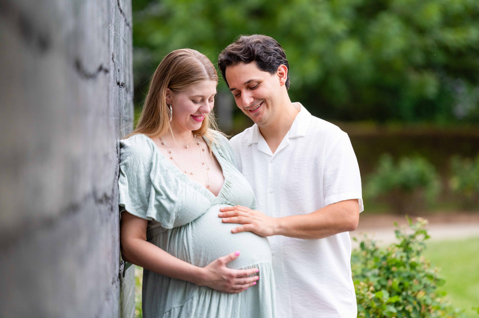 Dreamy flower field maternity photos Charlotte NC.  Couple standing in yellow flower field at North Carolina Museum of Art.