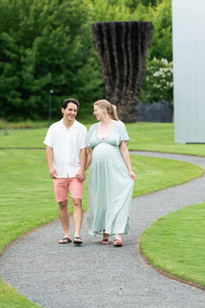 Dreamy flower field maternity photos Charlotte NC.  Couple standing in yellow flower field at North Carolina Museum of Art.