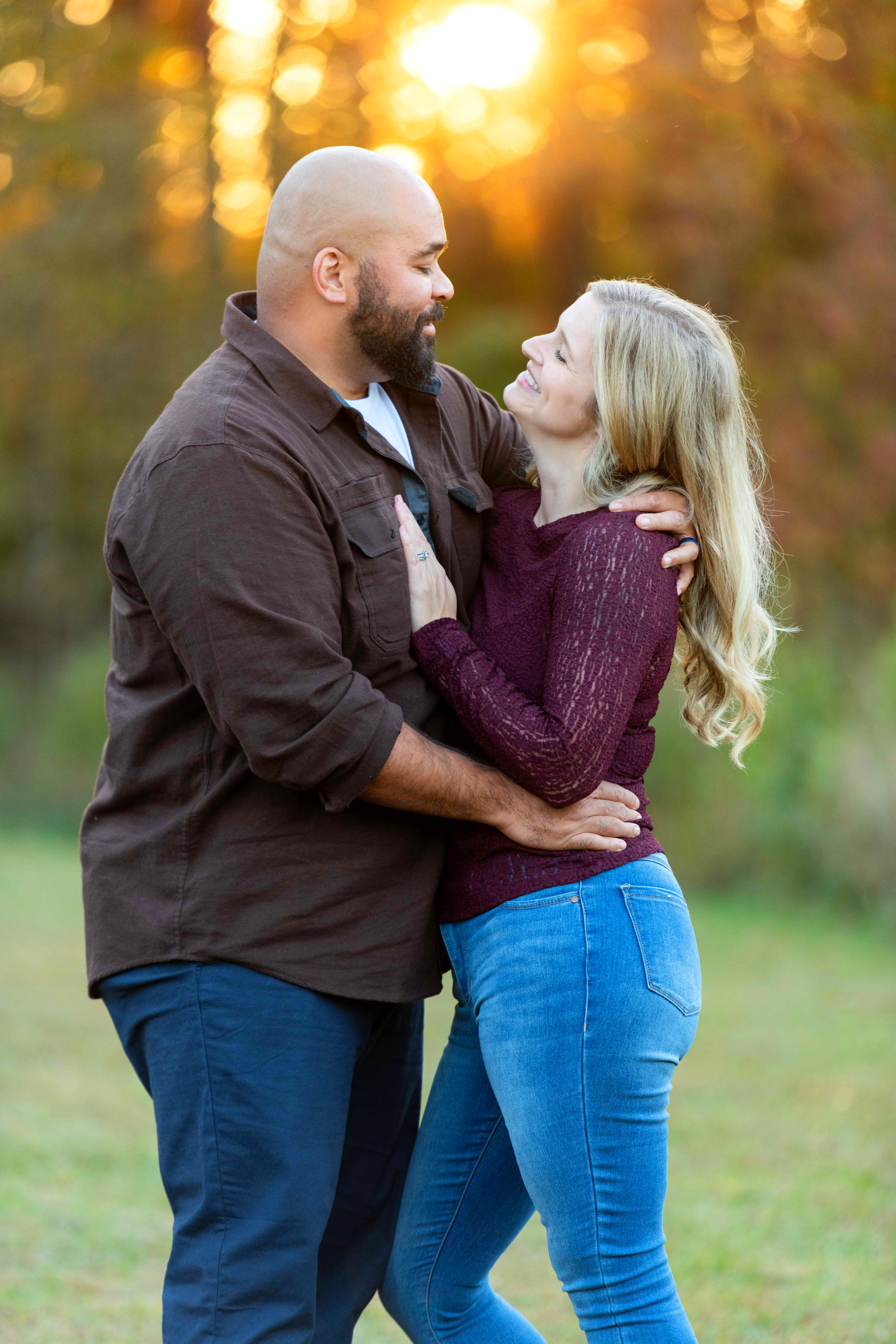 Couple posing for photo during sunset in grassy field.  Charlotte, NC family photographers.