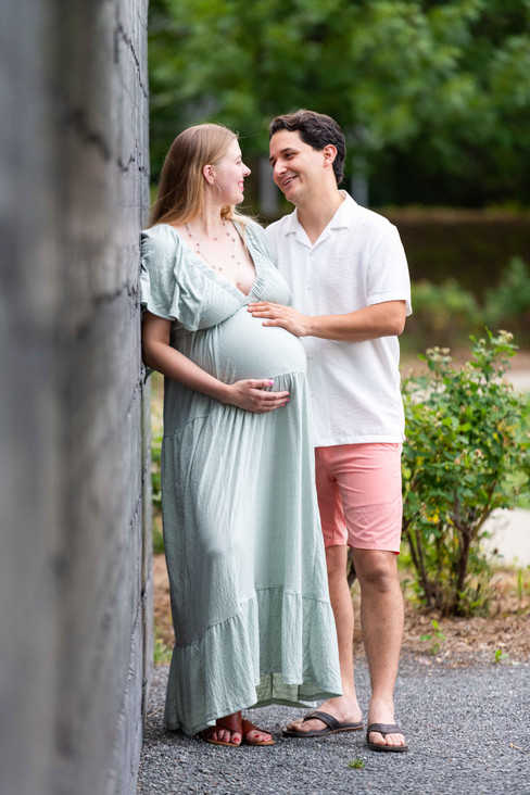 Dreamy flower field maternity photos Charlotte NC.  Couple standing in yellow flower field at North Carolina Museum of Art.