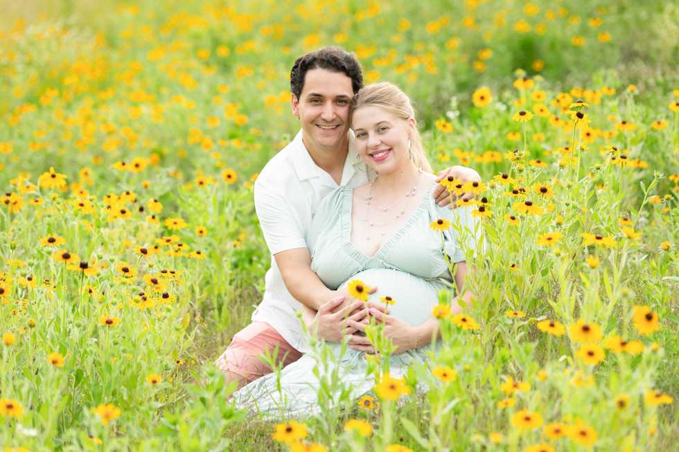 Dreamy flower field maternity photos Charlotte NC.  Couple standing in yellow flower field at North Carolina Museum of Art.