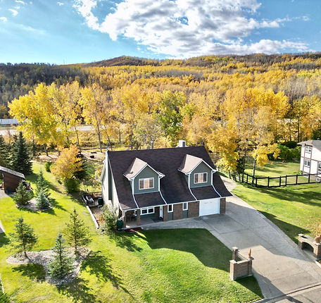 Enchanting autumn scene featuring a house surrounded by a beautifully landscaped yard in vibrant fall colors.