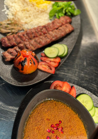 Zwei Teller mit gegrilltem Fleisch, Reis, Tomaten und Gurken. Speisekarte.