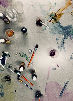 paint and art supplies laid out on a table with paint smears