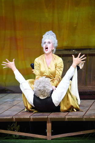 Christianne Bélanger in ‚Cendrillon‘ im goldenen Kleid, dramatische-humoreske Szene mit einem Partner auf der Bühne.