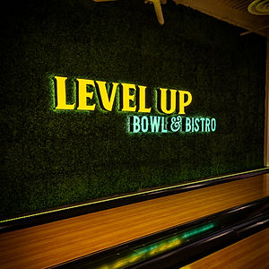 Neon Level Up sign inside Level Up Bowl & Bistro bowling and arcade venue