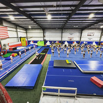 Young athletes holding a cheer pose during a Peak Performance stunt session.