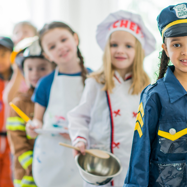 Children in chef and police costumes playing in Tiny Town at Willits Kids Corner